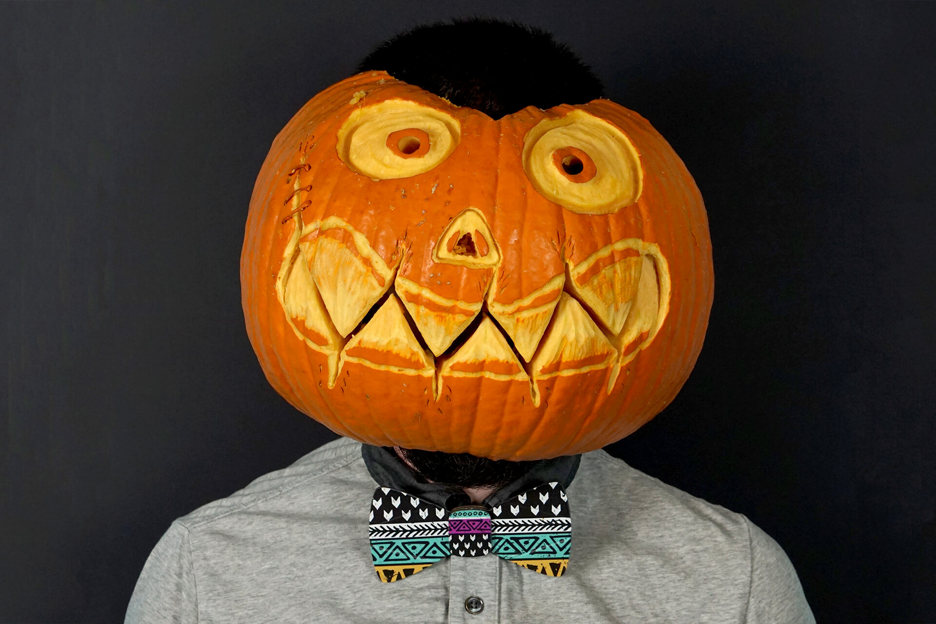 A lifestyle shot of the cardboard doodle bow tie on someone wearing a pumpkin head